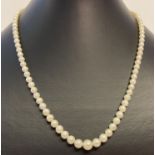 A vintage graduating cream pearl necklace with silver clasp.