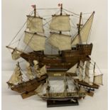 A vintage wooden model of The Golden Hinde with cloth sails, metal canons and red painted trim.