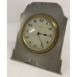 A small Art Deco silver framed bedside/table 8 day clock with engine turned decoration.