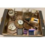 A box of mixed items to include steins, barometers, boxed cufflinks and a vintage tape measure.