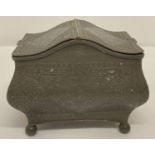 A decorative 2 sectional pewter tea caddy raised on ball feet.