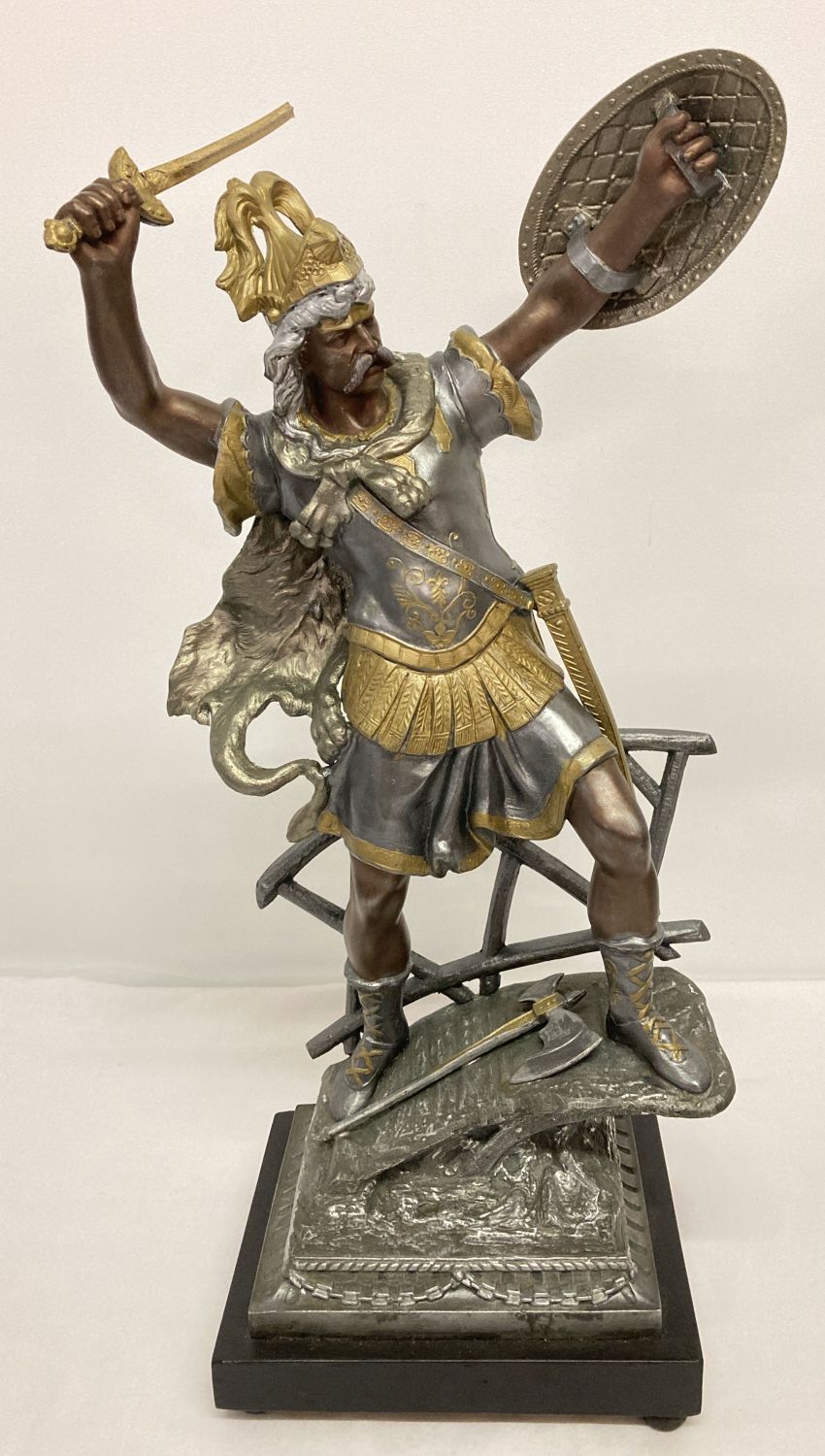 A large cast metal figure of a centurion standing on a bridge on a black fixed plinth with bun feet.