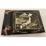 A vintage black lacquer Japanese photo album containing a quantity of 1950's military photo's.