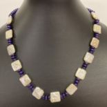 An 18" freshwater pearl and dyed purple quartz beaded necklace with white metal S shaped clasp.