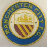A circular shaped painted cast iron Manchester City F.C. wall plaque.