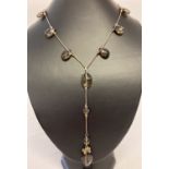 A modern design, faceted smoked glass drop style necklace with silver clasp.