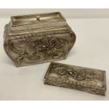 A Chinese decorative metal sarcophagus shaped tea caddy with dragon panel detail.