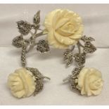 A vintage matching brooch and clip on earrings with carved rose detail and set with marcasites.