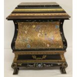 An Oriental style painted metal box with wooden stand and lid.