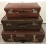 A collection of 3 vintage suitcases of graduating sizes.