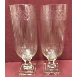 A pair of cut glass vases raised on pedestal stems with engraved detail and channelled design.