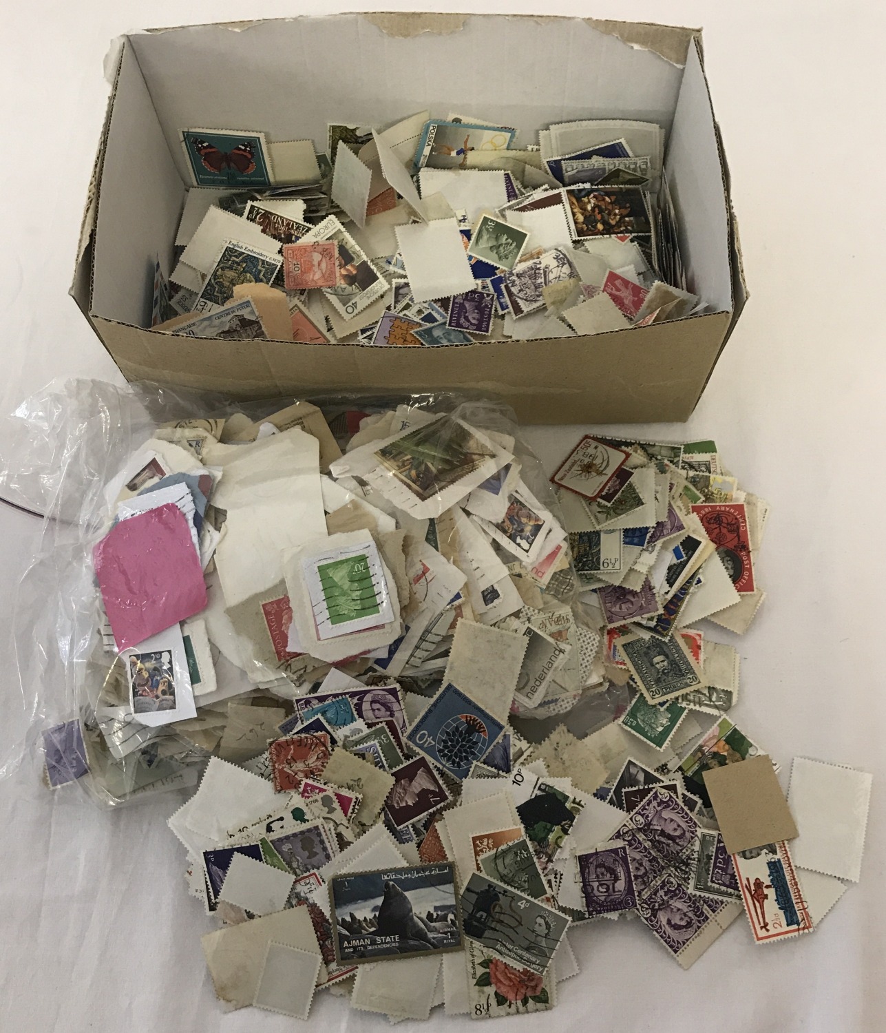 A box of assorted vintage British and foreign loose, used stamps.