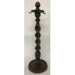 A dark oak barley twist companion stand with metal hooks.