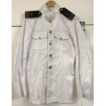A vintage US Navy style white tunic with buttons and shoulder boards.