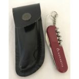 A Swiss Army Novartis multi-tool penknife in leather sheath.