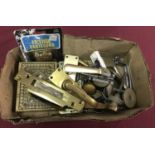 A box of assorted metal door furniture.