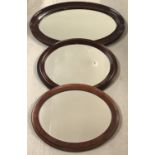 3 vintage oval shaped mirrors with mahogany coloured frames.