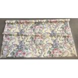 A rolled length of floral design blind material.