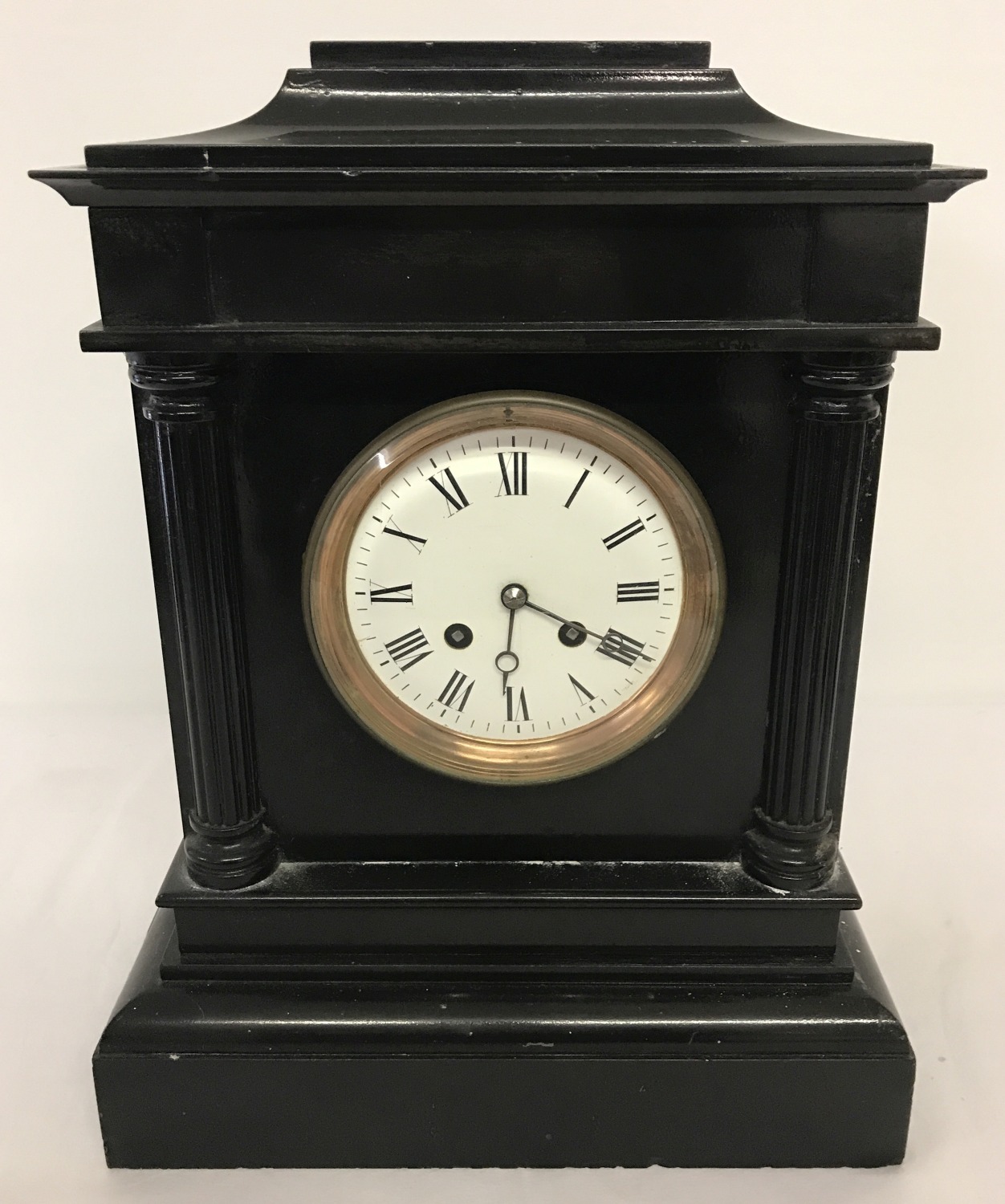 A Victorian black slate mantle clock with column detail.