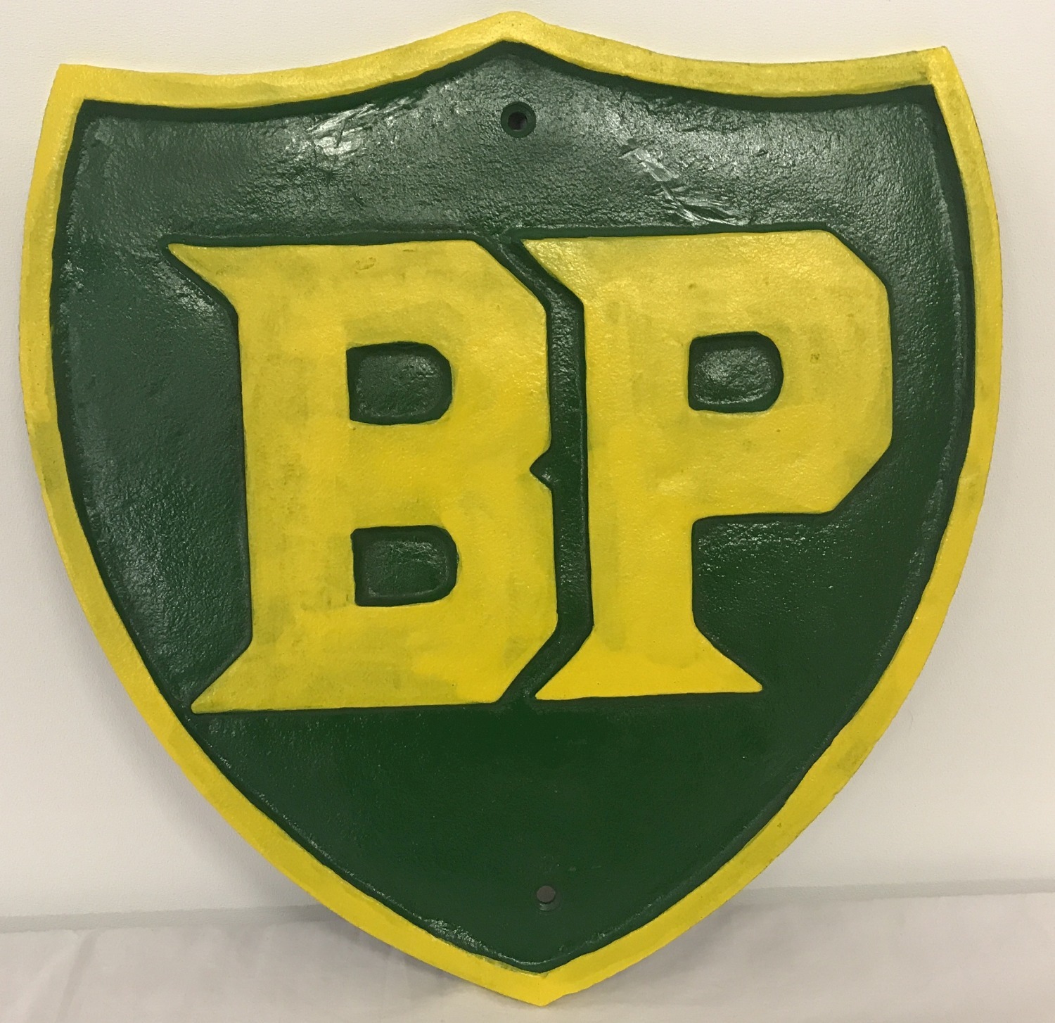 A large green and yellow painted cast iron BP wall hanging plaque.