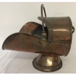 A Victorian copper coal scuttle with riveted swing handle.