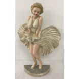 A painted cast iron door stop in the shape of Marilyn Monroe.