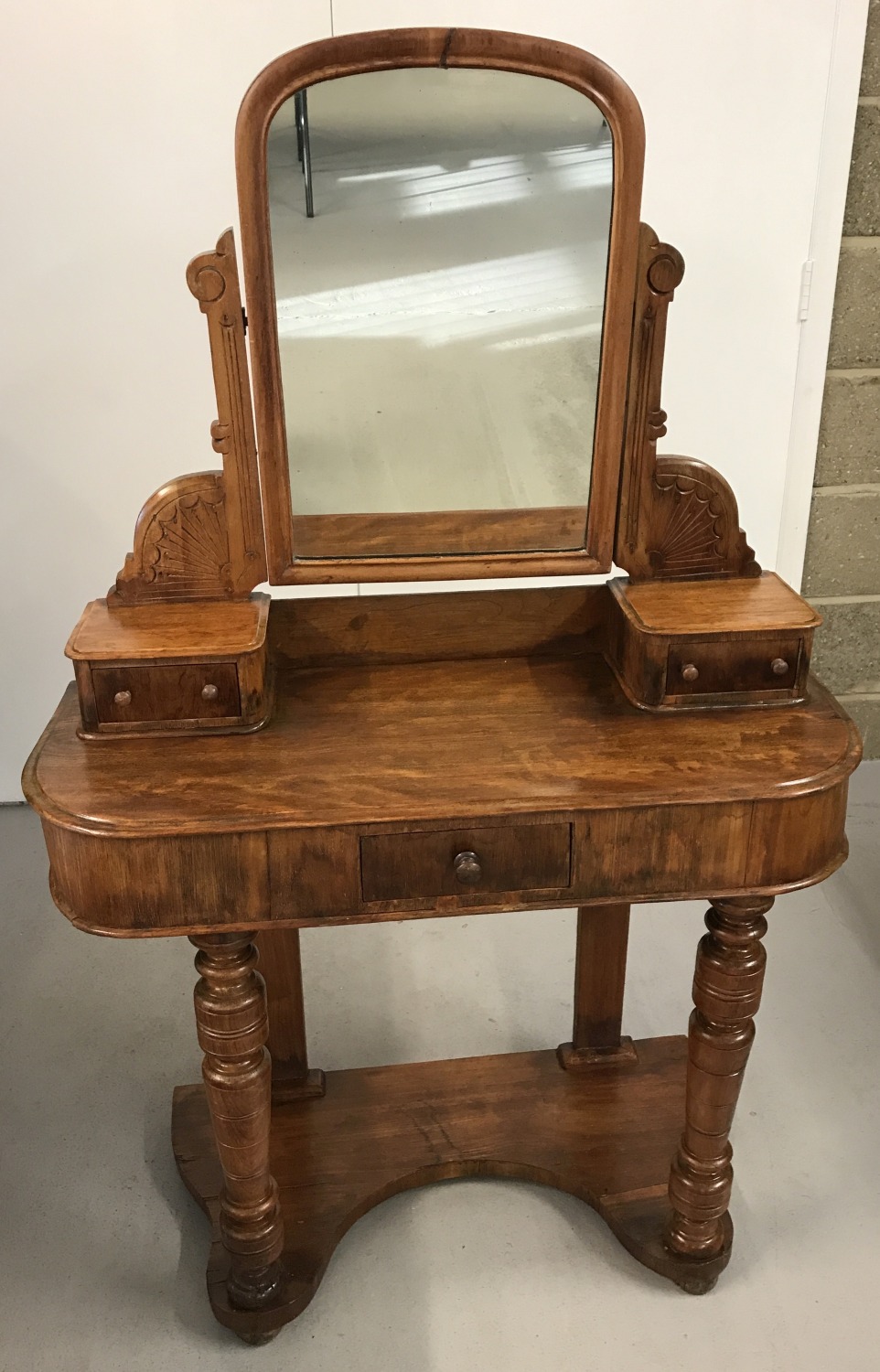 A Victorian mahogany veneer ladies dressing table with turned front legs and carved detail to top.