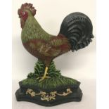 A painted cast metal doorstop in the shape of a cockerel.