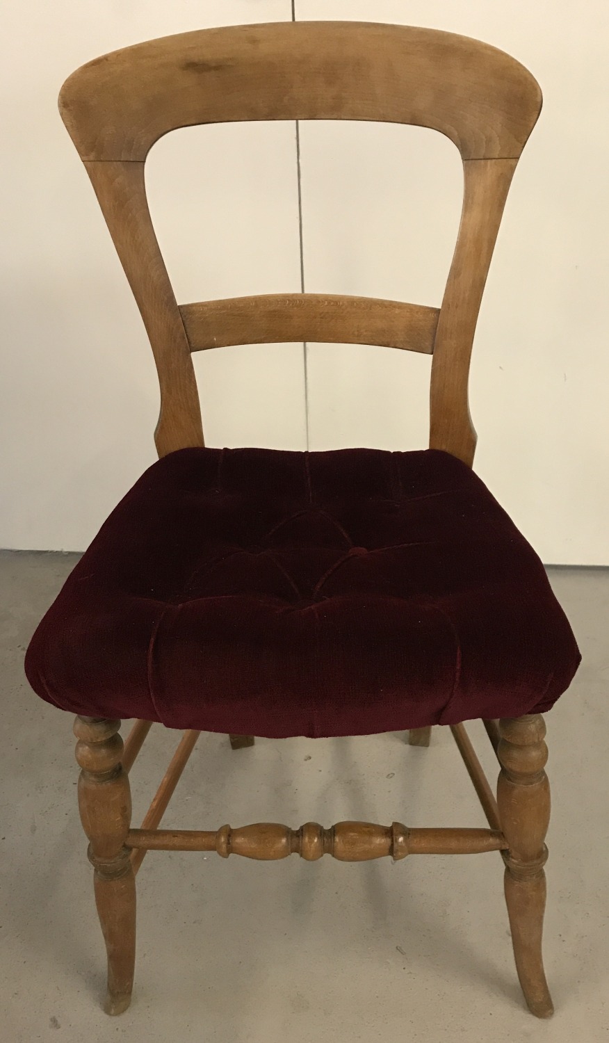 A vintage pine balloon back bedroom chair with turned legs and red velvet upholstery.