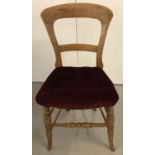 A vintage pine balloon back bedroom chair with turned legs and red velvet upholstery.