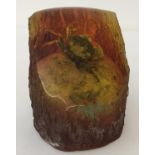 A figurine of a small fossilised crab sitting on a pebble set in resin, possibly amber.