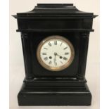 A Victorian black slate mantle clock with column detail.