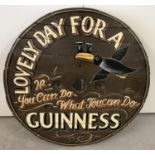 A large wooden circular shaped table top with painted Guinness design.