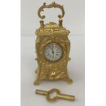 A miniature decorative, Regency style, gilt bronze carriage clock complete with key.