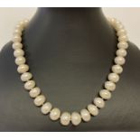 A 17" string of larger oval shaped cream freshwater pearls, with magnetic clasp.