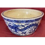 A large Chinese blue and white hand painted bowl/planter with dragon detail to outer bowl.