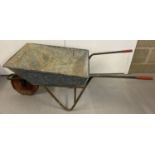 A vintage galvanised wheel barrow with 'Ironcrete' marked handle grips.
