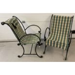 A pair of heavy black wrought iron garden chairs with green and cream stripe detachable covers.