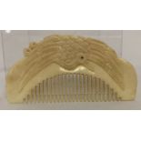 A carved bone comb with bird detail to handle.