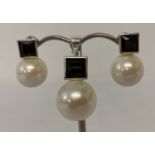 A pearl and black spinel pendant with matching earrings.