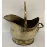 A vintage brass coal scuttle bucket with swing handle and riveted decorative tipping handle.