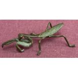 A small bronze figure of a Praying Mantis.