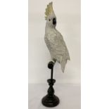 A modern ornamental resin figurine of a Cockatoo on a perch.