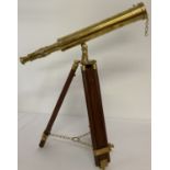 A brass telescope mounted on a tripod wooden extending stand.
