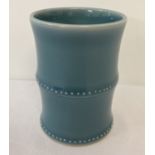 A blue glazed ceramic brush pot in the form of bamboo.