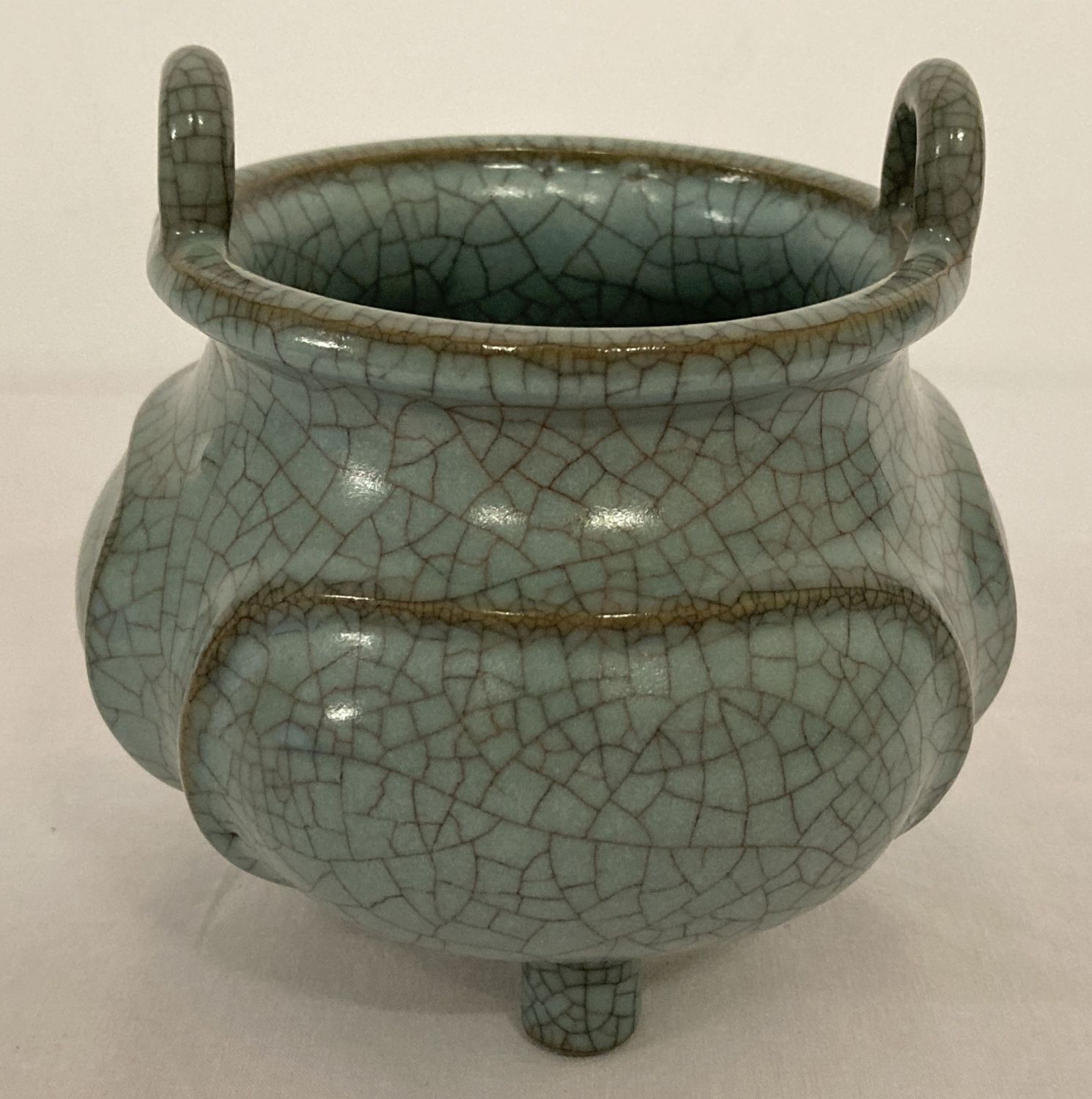 A blue/green crackle glaze ceramic censer, with loop handles and tripod feet.