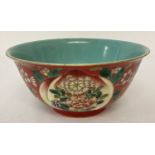 A Chinese ceramic bowl with decorative outer bowl and blue/green glaze interior.