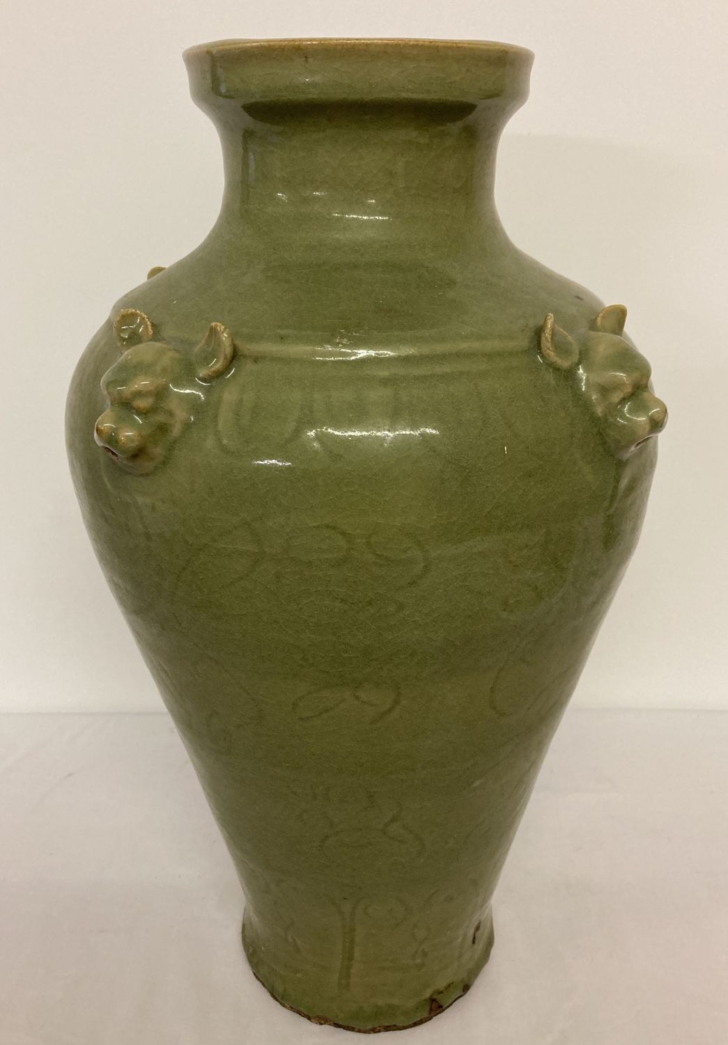 A very large celadon glaze vase of bulbous form, with animal head detail.