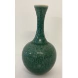 A small ceramic slim necked vase with dark green speckled glaze and ring mark to underside.