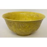 A Chinese ceramic bowl with yellow lustre glaze and raised dragon detail to outer bowl.